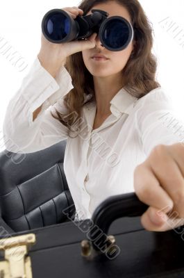 female holding bag and looking through binocular