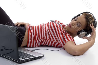 woman holding headphone and looking at laptop