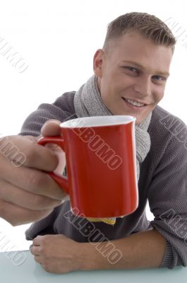 handsome young man showing coffee mug