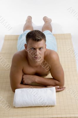 male lying on mat ready to take spa treatment