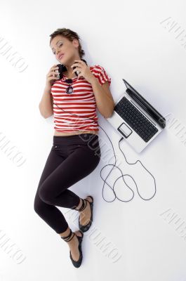 laying woman with laptop and headphone
