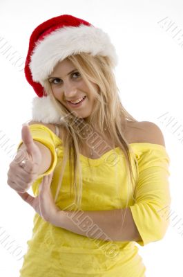 woman with christmas hat showing good luck sign