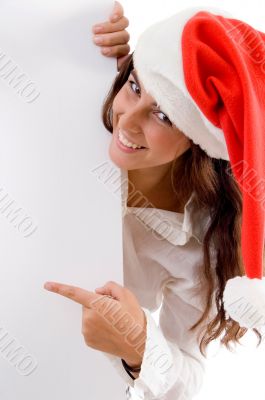 female wearing christmas hat and pointing placard