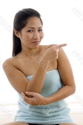 young female in towel indicating aside