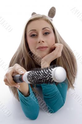 laying woman holding roller comb