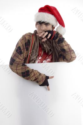 boy wearing christmas hat pointing placard