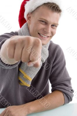 smiling young man with christmas hat showing punch