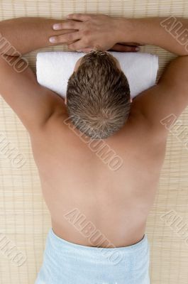 male lying on mat ready to take spa treatment