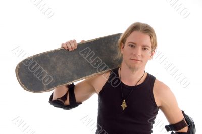 handsome guy holding skateboard on his shoulder