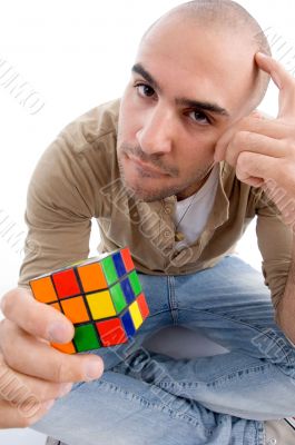confused man holding puzzle cube