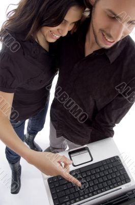 standing young couple looking into laptop