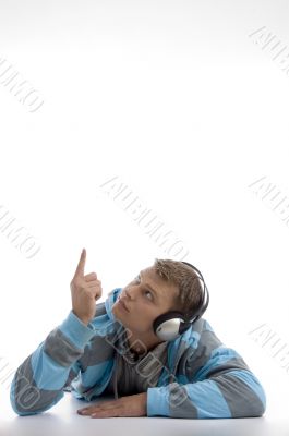 laying young man with headphone pointing upward