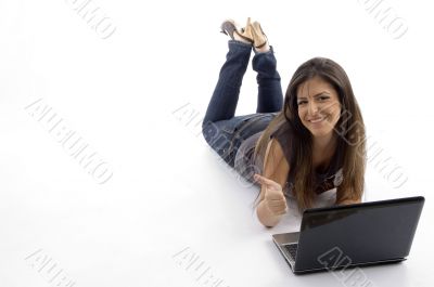young female lying down and working on laptop
