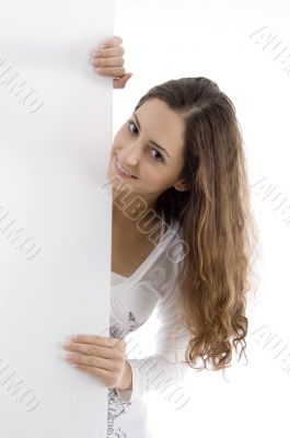 young caucasian woman peeping over placard