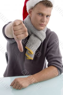 young man with christmas hat showing thumb down