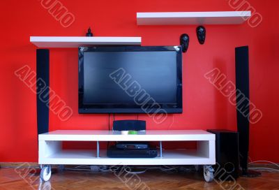big lcd televison on red wall, vivid bright colors