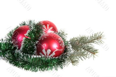 Three red christmas balls and branch of fir tree.