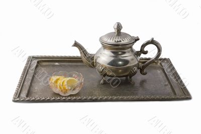 Teapot on a tray served with lemon slices