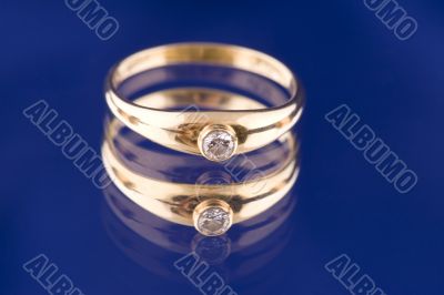 Golden ring with stone on blue