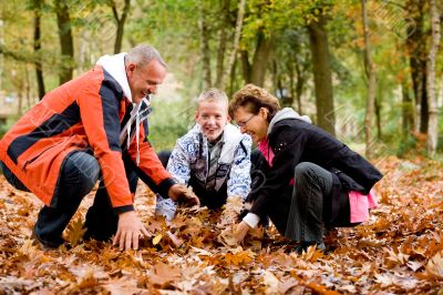 Happy family picking up the leafs