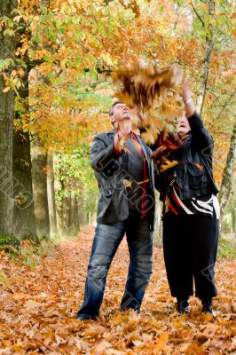 Older couple tossing leafs