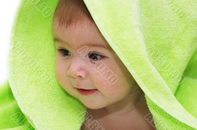 baby looking out from under blanket