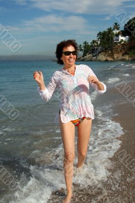 Happy woman running on the beach Happy woman running on the beach