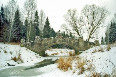 Ancient bridge over iced river