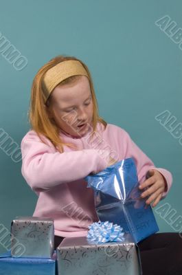 little red girl is opening her christmas presents