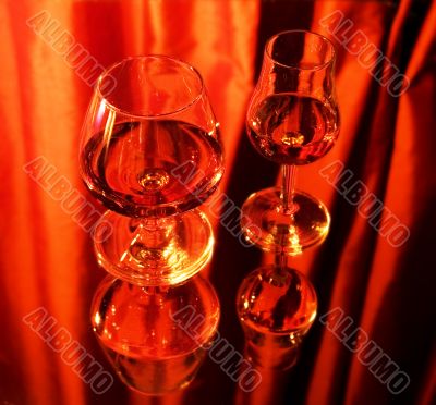 Two glasses with brandy on mirror