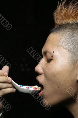 Punk asian man eat pills