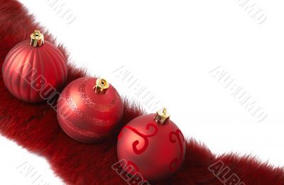 Three red Christmas baubles on fur