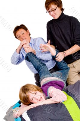 Mother and son are tickling the boy