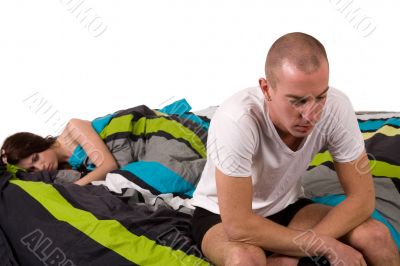 Young worried couple in bed with relation problems