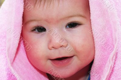 baby looking out from under blanket