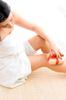 woman scrubbing her legs on white background