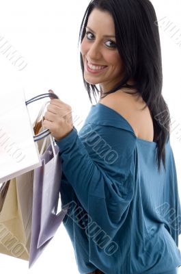 side view of smiling model carrying carry bags