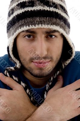 man wearing winter cap shivering from cold