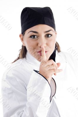 young beautiful chef shushing with finger