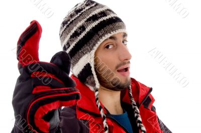 man wearing winter cap and jacket with a pointing