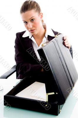 businesswoman putting document in briefcase
