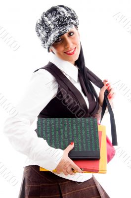 student wearing cap holding her study material