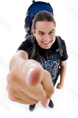 young traveler with bag pack pointing at camera