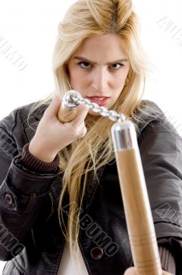 front view of aggressive female holding nunchaku