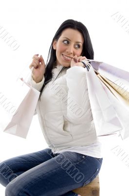 side pose of smiling woman holding shopping bags