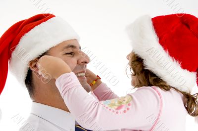 daughter stretching father`s cheeks