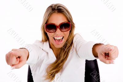 female with sunglasses pointing with both hand