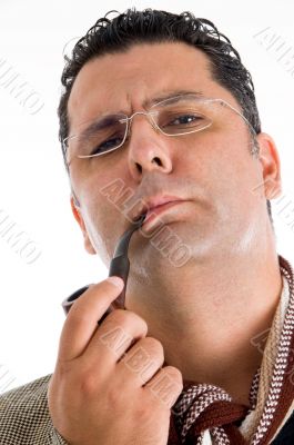 adult man in coat smoking tobacco pipe