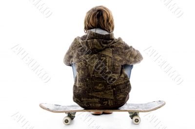 back pose of boy sitting on skateboard back pose of boy sitting on skateboard
