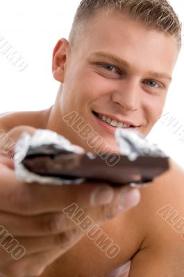 muscular man offering chocolate